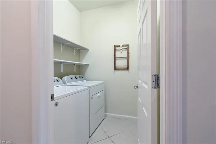 Laundry room with light tile patterned floors and independent washer and dryer