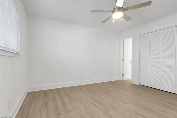 Unfurnished bedroom featuring light wood-type flooring, a closet, and ceiling fan