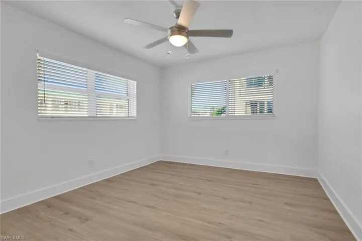 Unfurnished room featuring light wood-style flooring, ceiling fan, and healthy amount of natural light