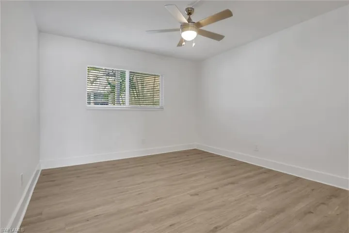 Spare room with wood finished floors and ceiling fan