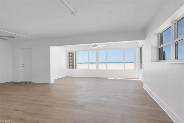 Unfurnished room with ceiling fan, light wood-style flooring, and a water view