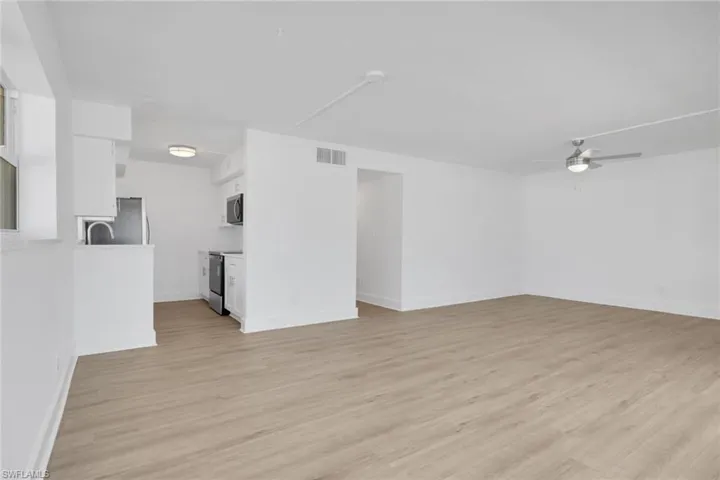 Unfurnished living room featuring ceiling fan and light wood-type flooring