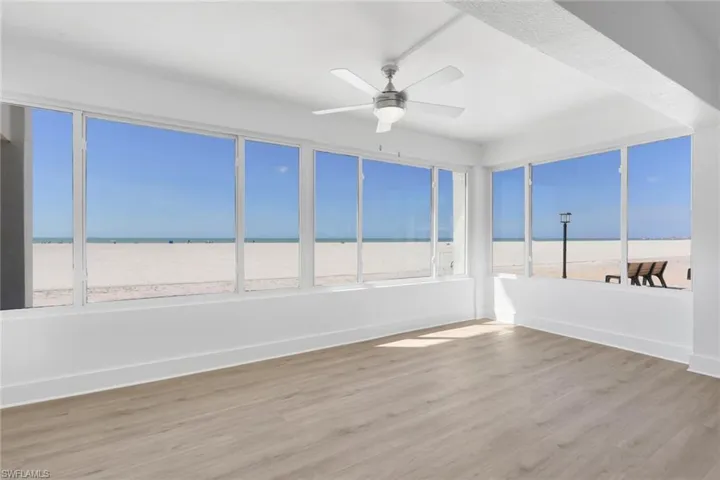 Unfurnished sunroom with wood finished floors, a water view, and healthy amount of natural light