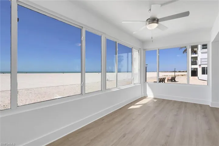 Unfurnished sunroom with wood finished floors and baseboards