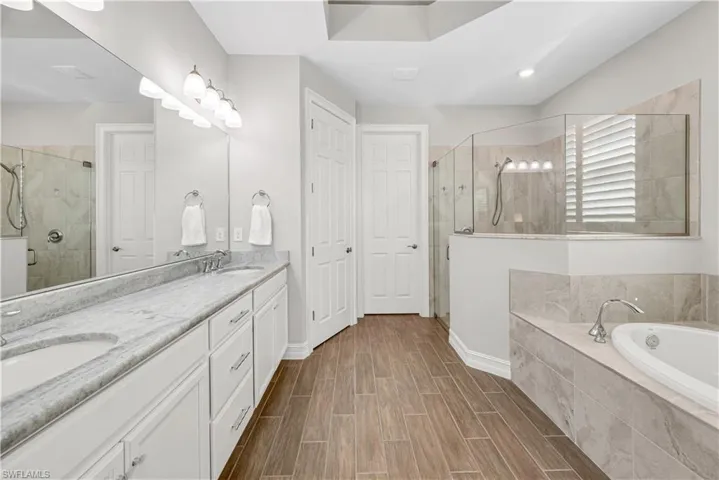 Bathroom featuring plus walk in shower and dual bowl vanity