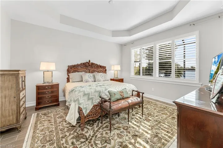 Bedroom with hardwood / wood-style floors and a raised ceiling