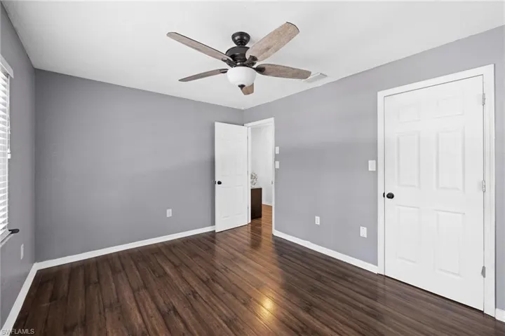 Unfurnished bedroom with dark hardwood / wood-style flooring and ceiling fan