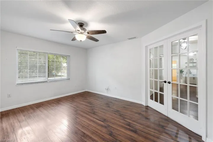 Spare room with dark hardwood / wood-style floors, ceiling fan, a textured ceiling, and french doors