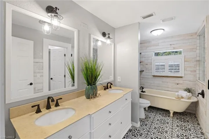 Bathroom with tile patterned floors, a bathtub, toilet, and vanity