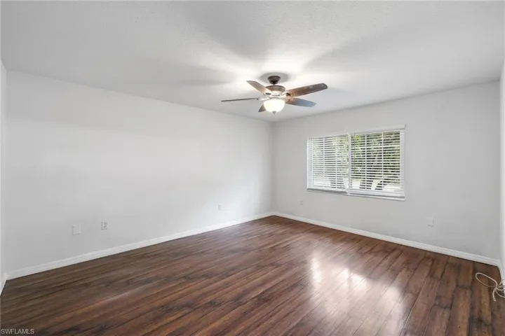Unfurnished room featuring ceiling fan, dark hardwood / wood-style flooring, and a textured ceiling