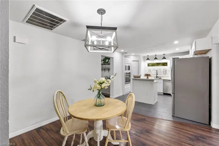 Dining room featuring dark hardwood / wood-style flooring, sink, and a chandelier
