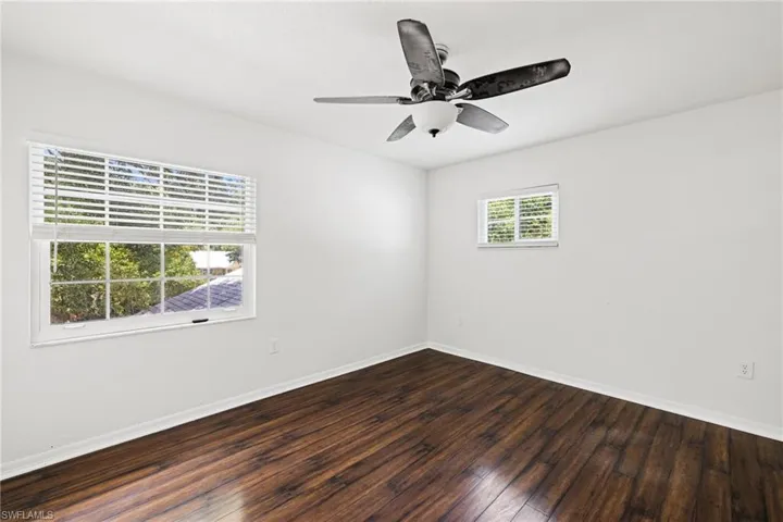 Spare room featuring ceiling fan and dark wood-type flooring