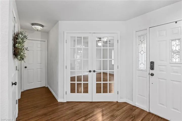 Foyer entrance featuring a textured ceiling, dark hardwood / wood-style flooring, and french doors