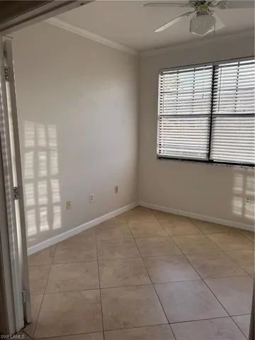 Unfurnished room featuring crown molding, light tile patterned floors, and ceiling fan