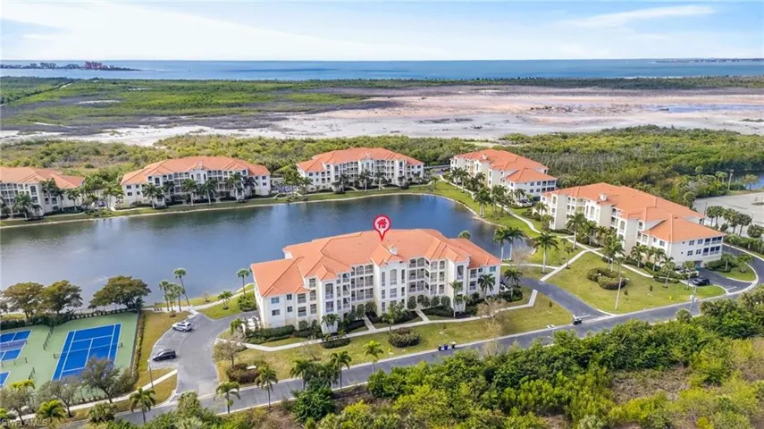 Drone / aerial view of apartment complex / building and a nearby body of water