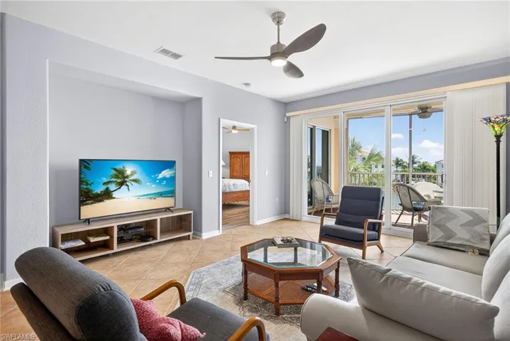 Living area with light tile patterned flooring and ceiling fan
