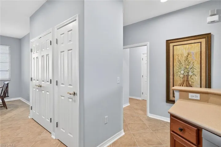 Hall with light tile patterned floors and baseboards