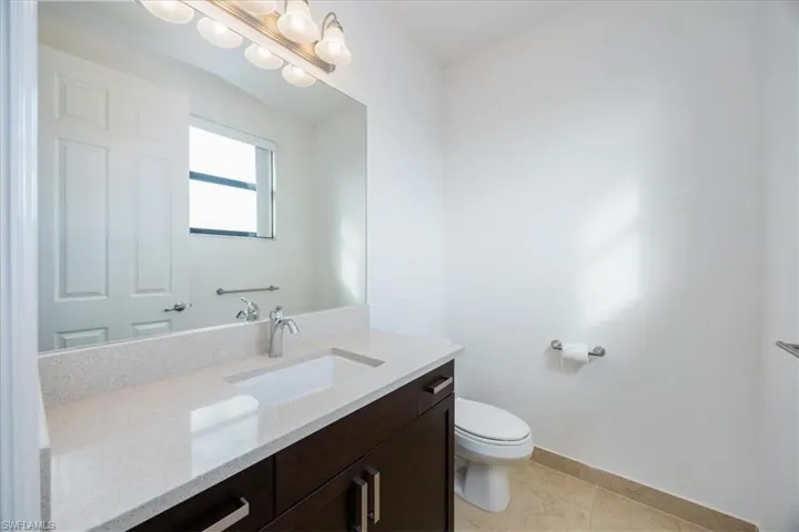 Bathroom featuring toilet, vanity, and tile patterned floors