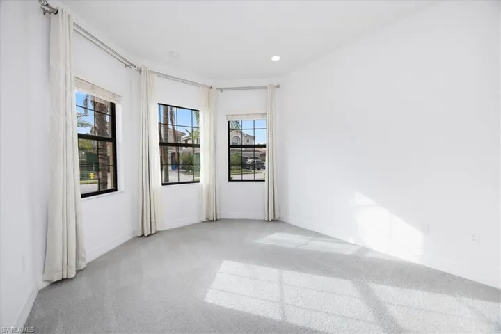 Spare room with a wealth of natural light and light carpet