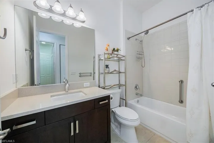 Full bathroom with tile patterned flooring, shower / tub combo, vanity, and toilet
