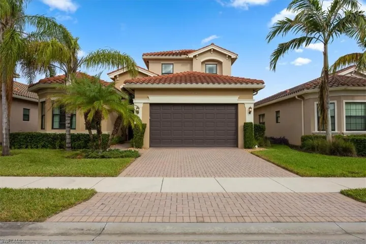 Mediterranean / spanish house with a front yard and a garage