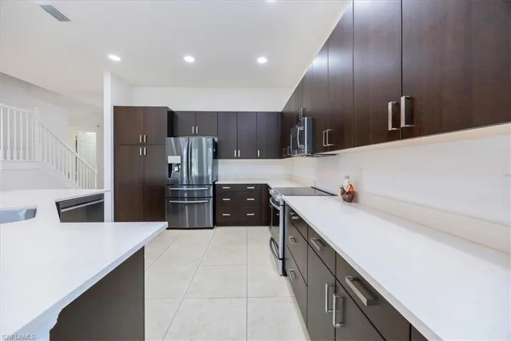 Kitchen with dark brown cabinets and stainless steel appliances
