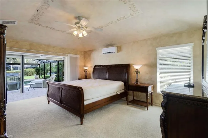 Carpeted bedroom with access to lanai. wall mounted AC is being removed.