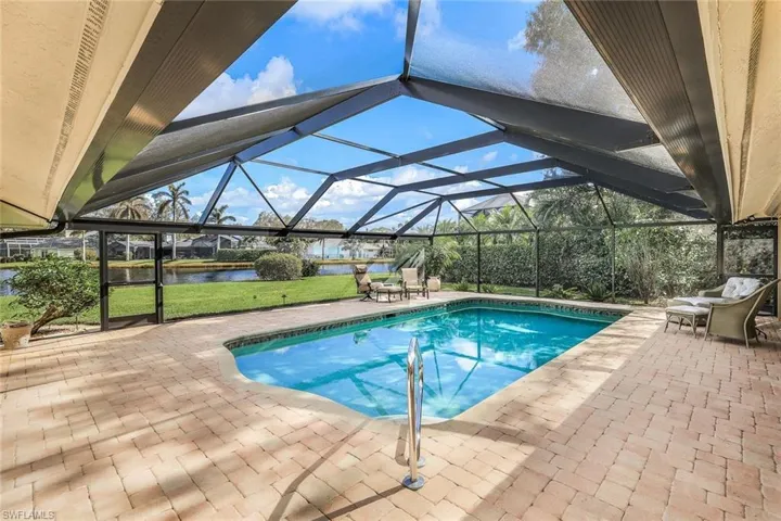 View of swimming pool with a lanai, a water view, and a patio area
