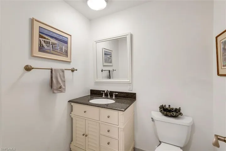 Powder room located off family room with toilet and vanity