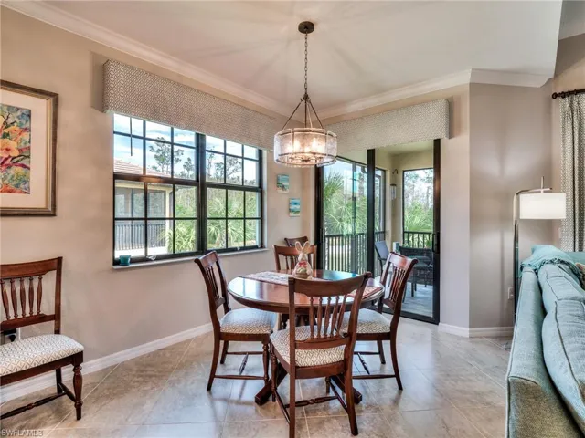 Dining area with a notable chandelier, ornamental molding, and a healthy amount of sunlight