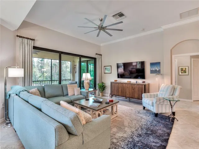 Tiled living room featuring crown molding and ceiling fan