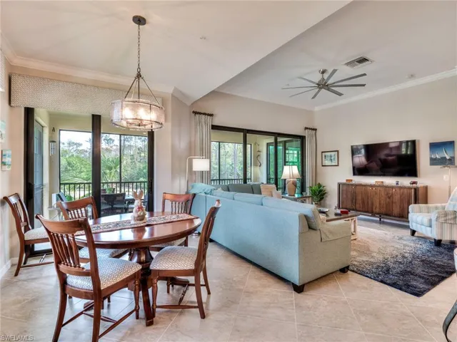 Dining room featuring a healthy amount of sunlight, crown molding, and light tile floors