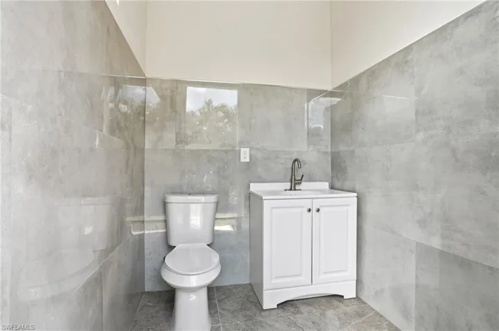 Bathroom with vanity and tile walls