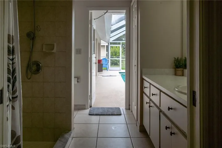 Bathroom with tile flooring, a shower with shower curtain, and vanity