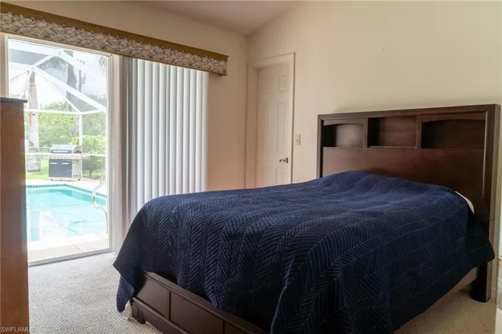 Bedroom with carpet, access to exterior, and vaulted ceiling