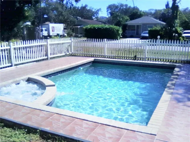 View of pool with a pool with connected hot tub