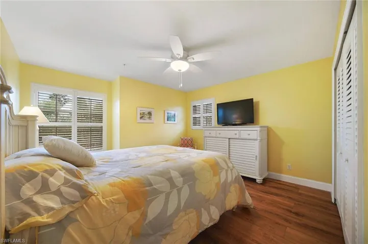 Bedroom featuring a closet, ceiling fan, and dark hardwood / wood-style flooring