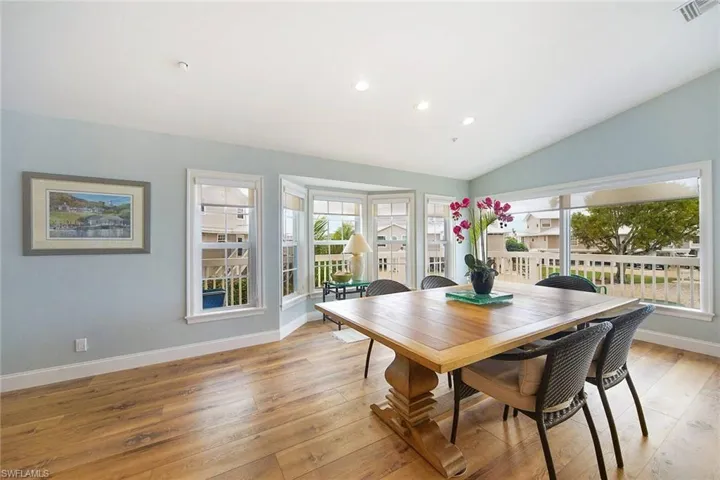 Dining room with light hardwood / wood-style floors and vaulted ceiling