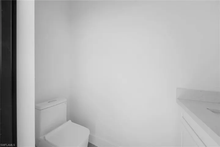 Half bathroom featuring vanity and toilet