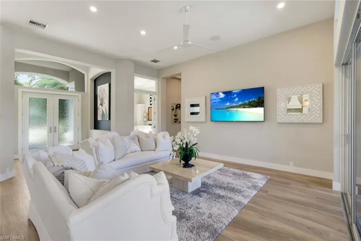 Living room featuring ceiling fan, french doors, and light wood-type flooring