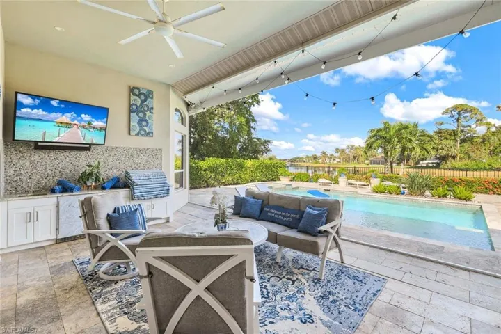 View of patio with an outdoor living space, an outdoor kitchen, a fenced in pool, and ceiling fan