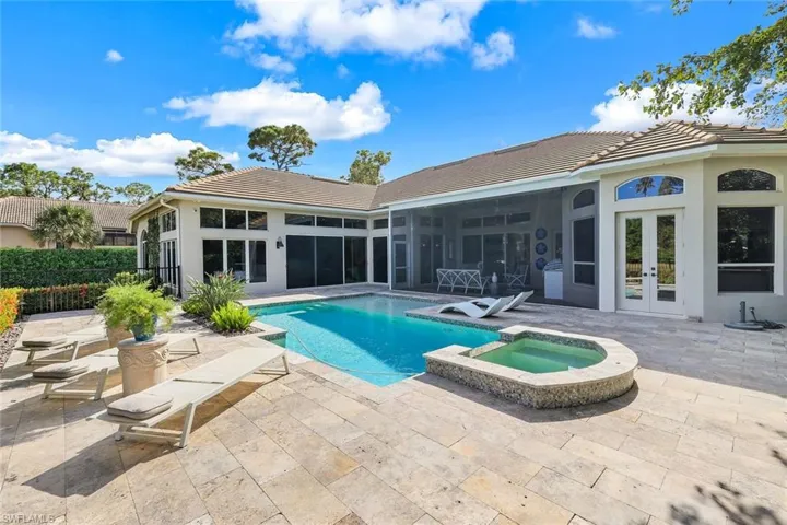 View of pool featuring an in ground hot tub, french doors, a patio area, and a sunroom