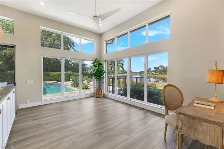 Sunroom with ceiling fan and a water view