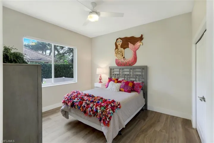 Bedroom with a closet, hardwood / wood-style flooring, and ceiling fan