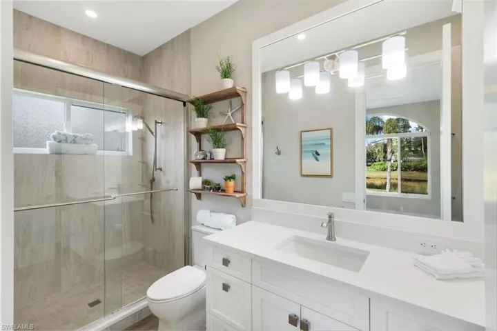 Bathroom with vanity, toilet, and an enclosed shower