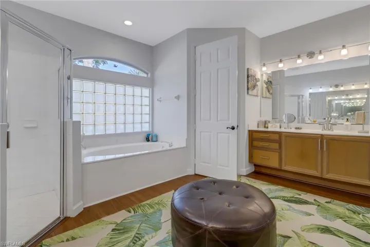 Bathroom featuring vanity, wood-type flooring, and independent shower and bath