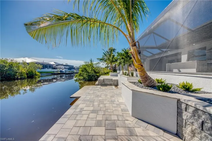 View of patio featuring a lanai and a water view