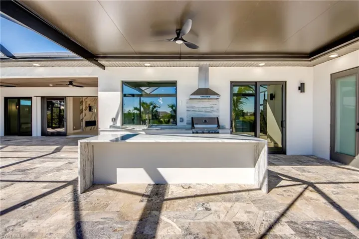 View of patio / terrace featuring an outdoor kitchen, ceiling fan, sink, and a grill