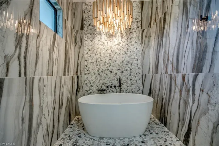 Bathroom featuring a bathtub and tile walls