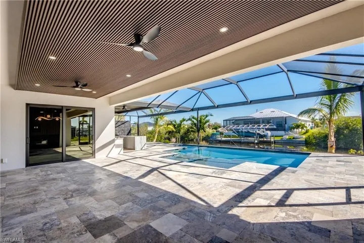 View of swimming pool with ceiling fan, a patio area, and a lanai